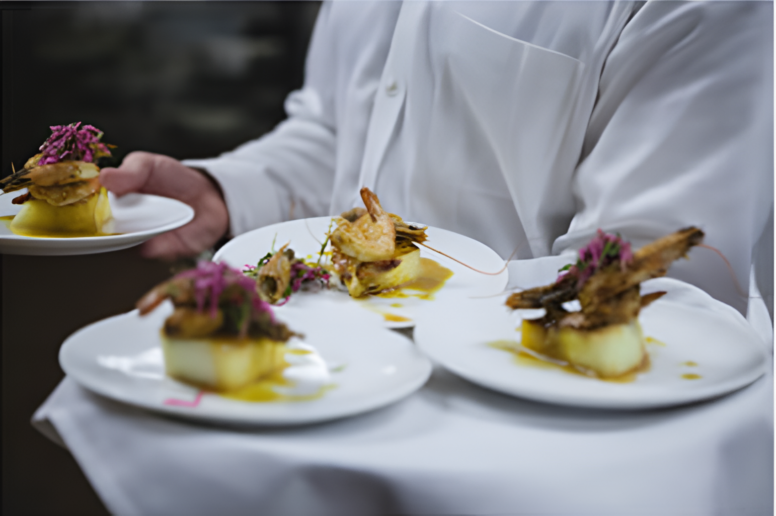 Chef carrying multiple dishes